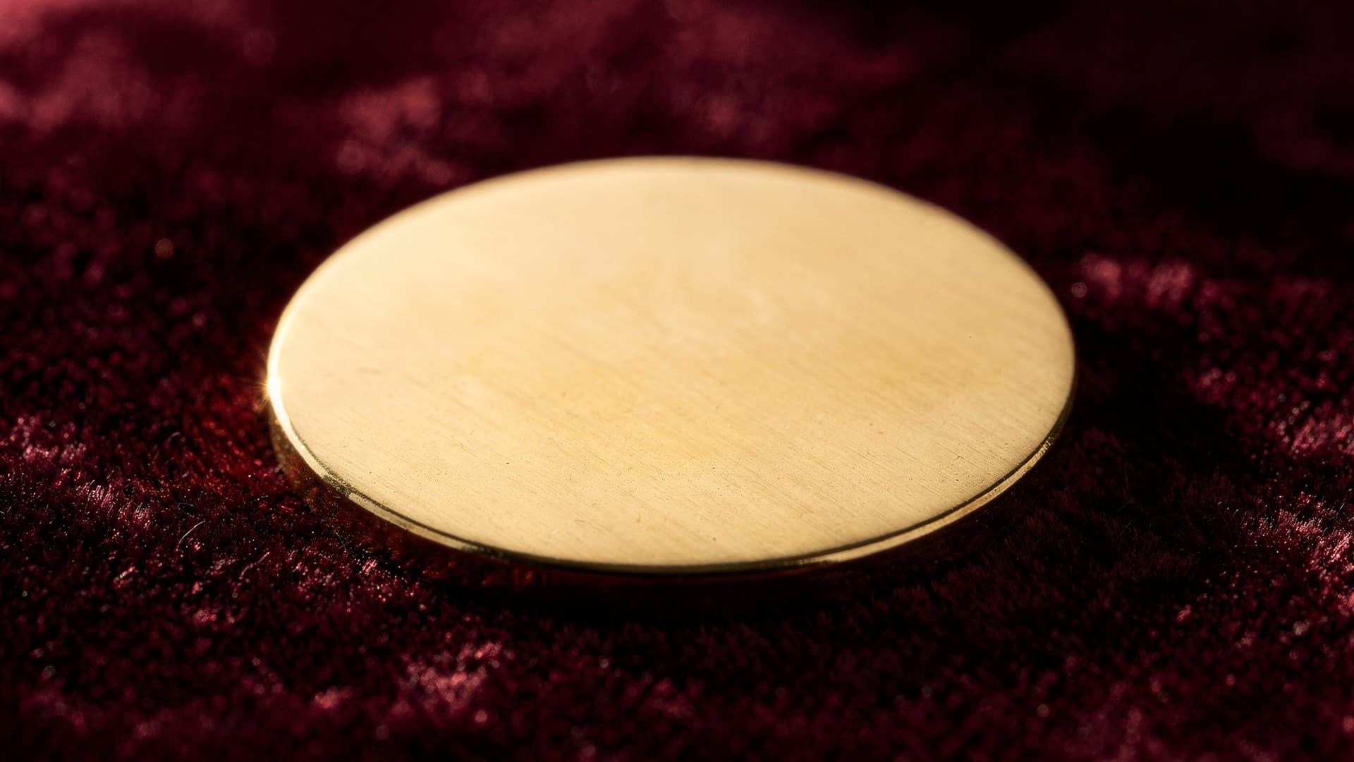 A polished brass medallion resting on burgundy cloth, symbolizing the personal integrity of The Code of Honour